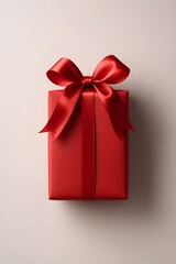 Minimalist top view of a vibrant red present box with a dramatic bow and ample copy space
