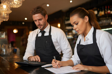 Restaurant Collaboration: A focused duo of waitstaff members, deep in concentration, collaborates seamlessly within a sophisticated restaurant setting.
