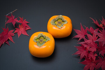 美しく紅葉したもみじの葉と秋の代表的な果物の柿
