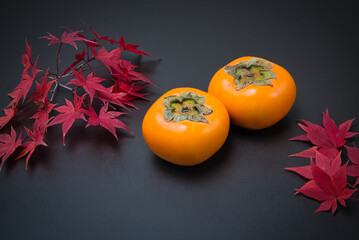 美しく紅葉したもみじの葉と秋の代表的な果物の柿