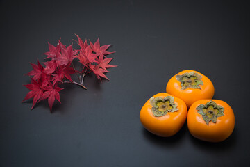 美しく紅葉したもみじの葉と秋の代表的な果物の柿