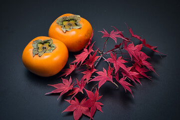 美しく紅葉したもみじの葉と秋の代表的な果物の柿