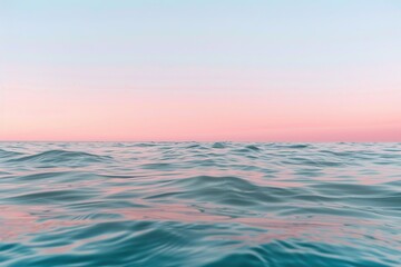 Obraz premium Gentle waves ripple across the turquoise water, blending seamlessly into a soft pastel sky at the horizon. This serene setting invites calm and reflection, perfect for a peaceful moment