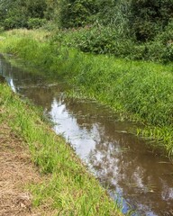 Drainage ditch running through lush green landscape