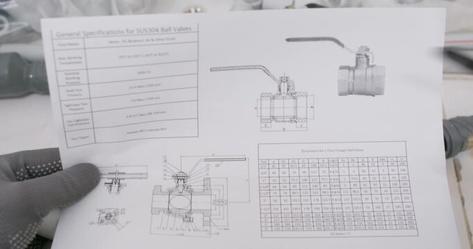 Gloved hand points to exploded diagram on manual sheet. Installer verifies assembly order and checks O ring placement confirming handle orientation with stem alignment