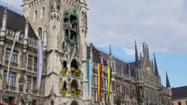 Detail of Rathaus New Town Hall with chime in city center. Located on Marienplatz square. Looking up perspective. Clock Tower or Glockenspiel close-up, Munich, Germany. 03. 10. 2025. Slow motion