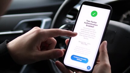 Closeup of a mans hands in a parked car reading a confirmation message that two-factor authentication has been successfully enabled. This clip embodies the moment of achieving digital peace of mind. - Powered by Adobe
