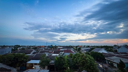 Overhead View of Dense Residential Rooftops Under a Dramatic Cloudy Sunset or Sunrise Sky