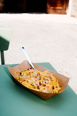 spaghetti alla carbonara in a brown paper bowl