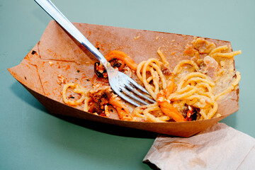 cardboard box with pasta leftovers on a table