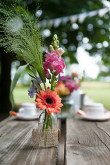 Wunderschöne Blumendekoration. Kaffeetrinken im Freien. Blumen Deko im Sommer.