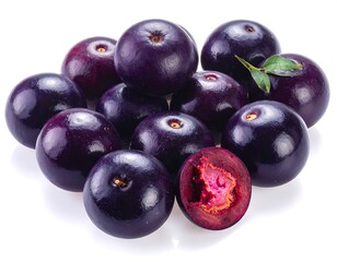 Fototapeta premium Pile of round, dark purple berries, some whole, others halved revealing bright pink interior and small leaf