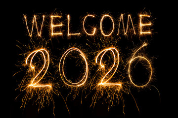 Happy New Year 2026. Burning sparkling text 2026 isolated on black background.