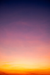 Sunset or sunrise sky with a vibrant gradient of orange, gold, and soft blue. Clear atmosphere with wispy clouds. Peaceful, natural light background. hope, freedom, new day Concepts, Vertical