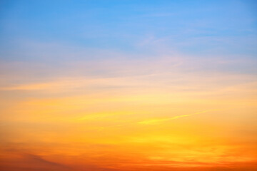 Sunset or sunrise sky with a vibrant gradient of orange, gold, and soft blue. Clear atmosphere with wispy clouds. Peaceful, natural light background. hope, freedom, new day and inspirational Concepts