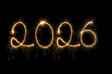 Happy New Year 2026. Burning sparkling text 2026 isolated on black background.