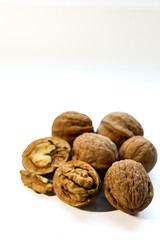 Whole and peeled brown walnuts on the white background