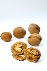 Whole and peeled brown walnuts on the white background