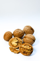 Whole and peeled brown walnuts on the white background