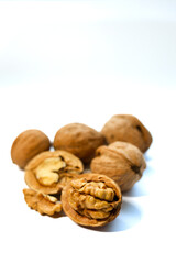 Whole and peeled brown walnuts on the white background