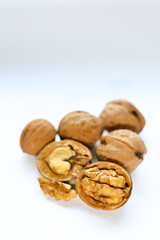 Whole and peeled brown walnuts on the white background
