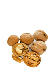Whole and peeled brown walnuts on the white background