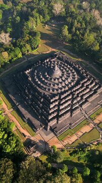 Aerial view of Borobudur Temple in Central Java, Indonesia. Ancient Buddhist monument at sunrise, surrounded by tropical jungle. UNESCO World Heritage Site, culture, history, and travel themes.