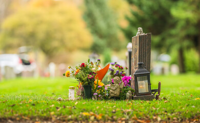 Colorful flowers and lantern placed on cemetery grave.