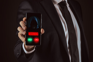Business Man Holding a Smartphone Displaying a Critical Digital 'Warning' from an Unknown Hooded Cyber Threat