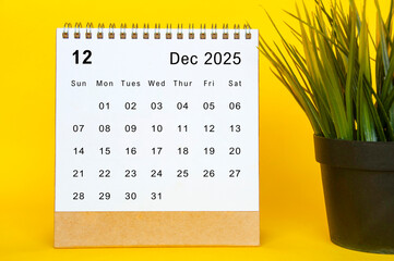 White December 2025 calendar on yellow cover background. Year end concept.