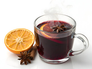 Steaming mulled wine with orange slice and star anise in a clear glass mug on white table