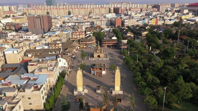 Kunming, China - 06 December 2025: Aerial View of urban buildings against a skyline, with pagodas and traditional architecture in the foreground, blending old and new in the Chinese city.