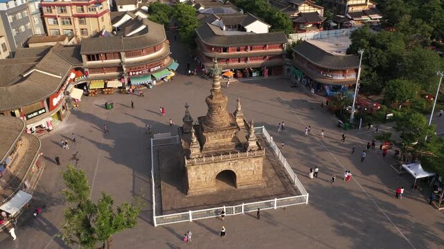 Kunming, China - 06 December 2025: Aerial View of an elaborate stone structure dominates the square, surrounded by people. The square is bordered by traditional Chinese buildings.