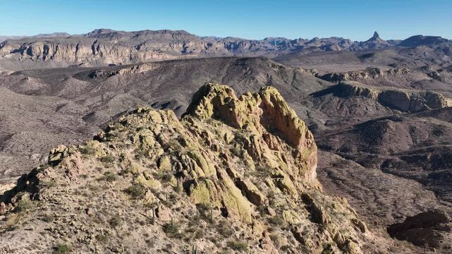 Aerial view of a rugged mountain range with sparse vegetation, showcasing the arid landscape and dramatic geological formations, Apache Junction, Arizona, United States.