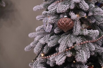 Snow-covered spruce branches with vintage garland toys on gray background with free space as Christmas decoration design