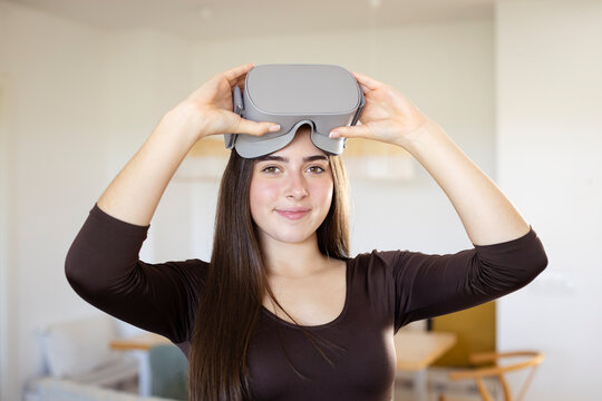 A teenage girl wearing virtual reality goggles on his head,