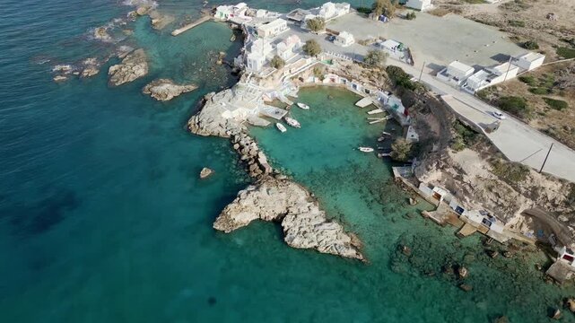 Aerial view of the quaint village of Mandrakia, where whitewashed houses meet turquoise waters, creating a striking contrast, Milos, Anatoliki Attiki, Greece.