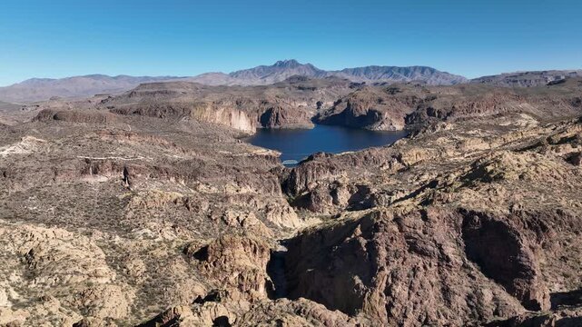 Aerial view of Canyon Lake surrounded by arid mountains and rugged terrain, showcasing the stark beauty of the landscape, Apache Junction, Arizona, United States.
