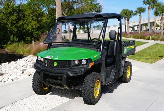 St Petersburg, Florida, U.S - Nov 9, 2025 - A green and black John Deere Gator Utility Vehicle model 845M parked on a concrete path