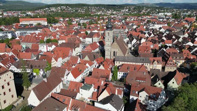 Aerial view of St. Martin church surrounded by red-roofed buildings, creating a warm, textured landscape under a bright sky, Forchheim, Bavaria, Germany.