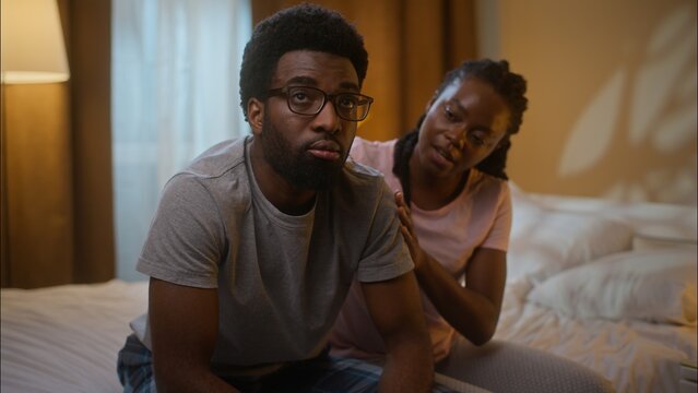 African American married family ethnic couple quarrel argument conflict guilty woman wife comforting calming ask for forgiveness annoyed man husband shaking head no never reject at home bedroom night