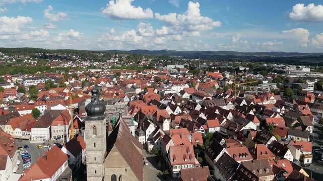 Aerial view of Forchheim's rooftops, with a prominent church steeple, contrasting with the surrounding green landscape, Forchheim, Bavaria, Germany.