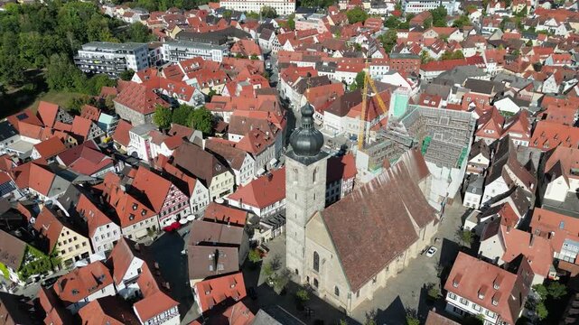 Aerial view of a church tower standing tall amidst a sea of buildings with vibrant red rooftops, creating a stunning tapestry of color, Forchheim, Bavaria, Germany.