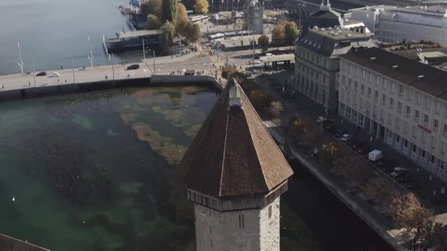 Aerial view of the historic Wasserturm standing tall amidst the Reuss river's aquatic vegetation, complemented by the city's architectural landscape, lucerne, lucerne, Switzerland.