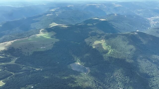 Aerial view of a dense forest canopy, a vibrant tapestry of green hues and textures creating an immersive natural landscape, Thann, Grand Est, France.