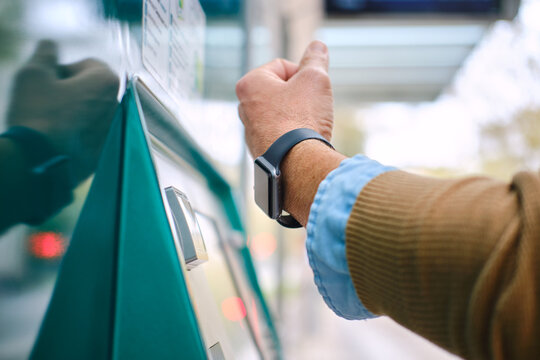 side view detail of adult Man paying for public transport using smartwatch. unrecognizable person