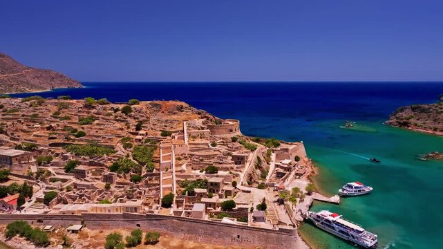 Aerial view of Spinalonga island fortress with its aged stone walls contrasting against the turquoise waters of the coast, Elounda, Lasithi, Greece.