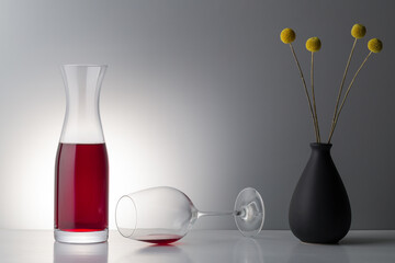 red wine with dried floweron bright background.