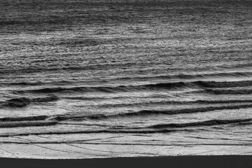 Obraz premium Monotone waves breaking softly along the shoreline