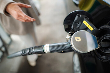 Obraz premium Person fueling car with diesel at gas station